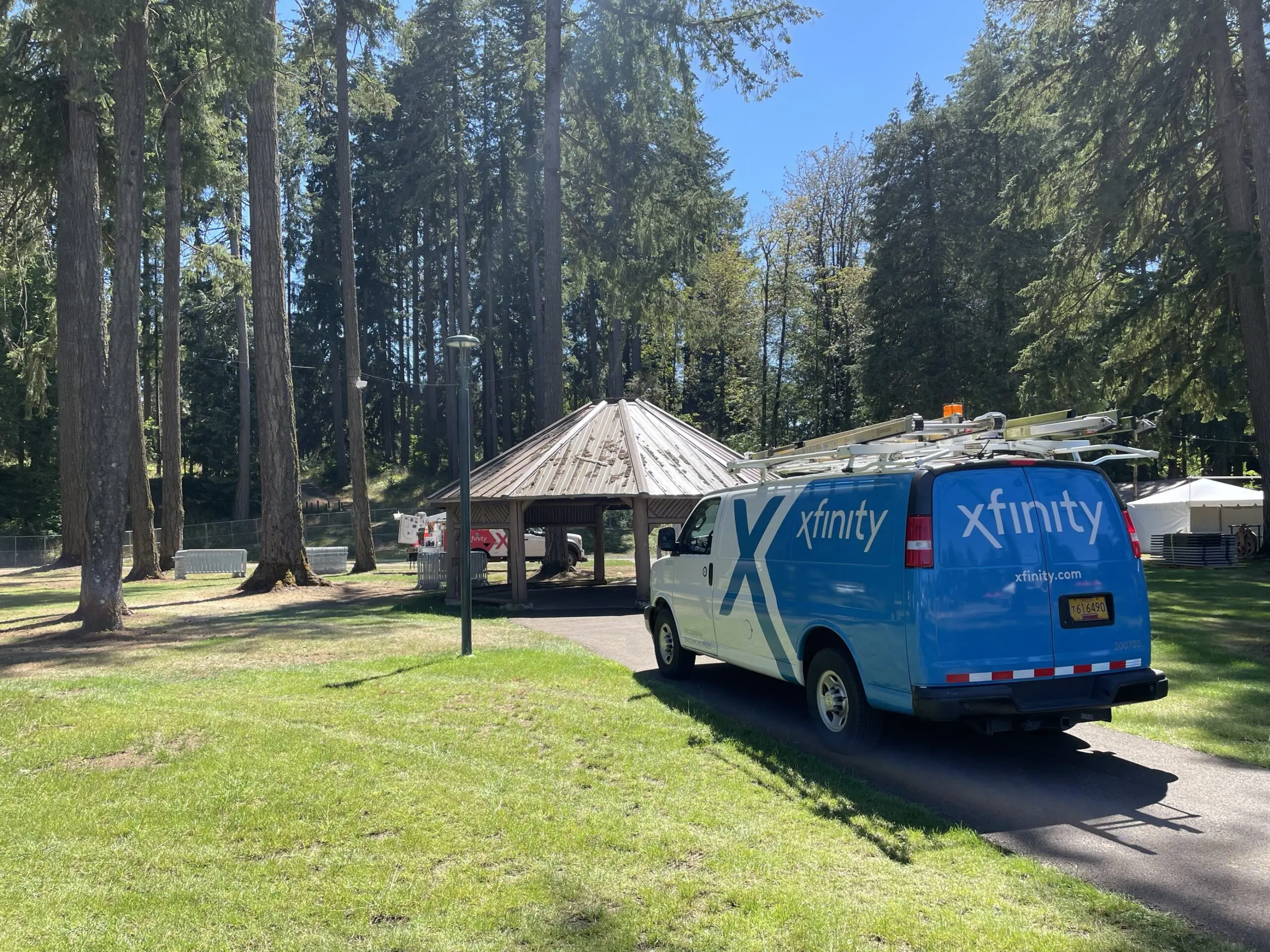 An Xfinity van parked in a park.