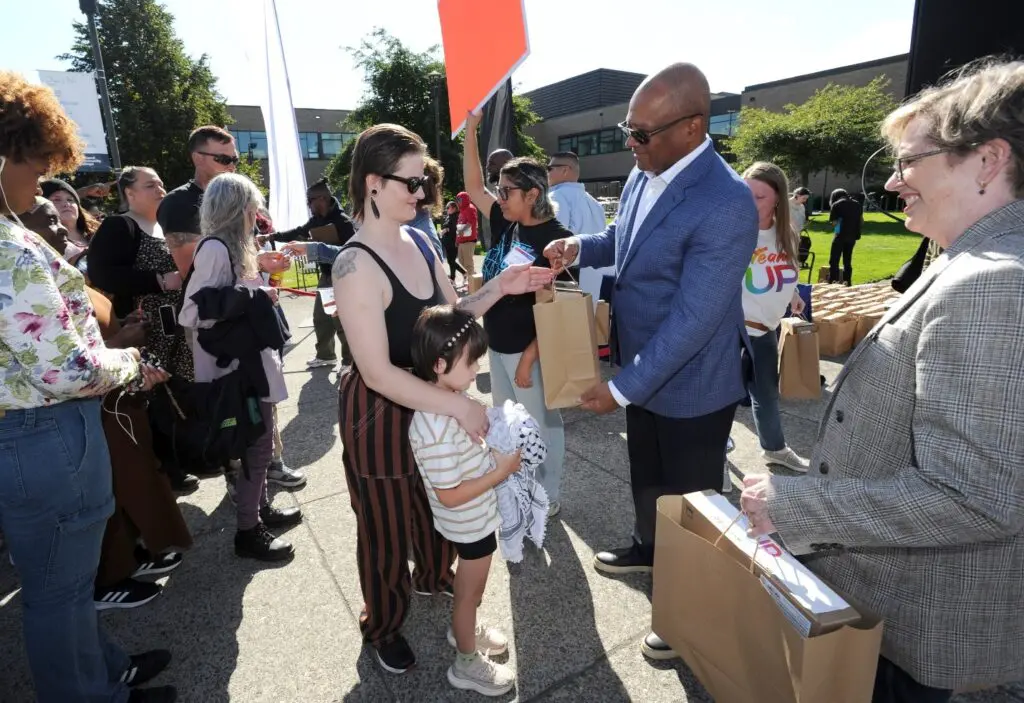 Comcast's Broderick Johnson hands a bag to a young woman. 