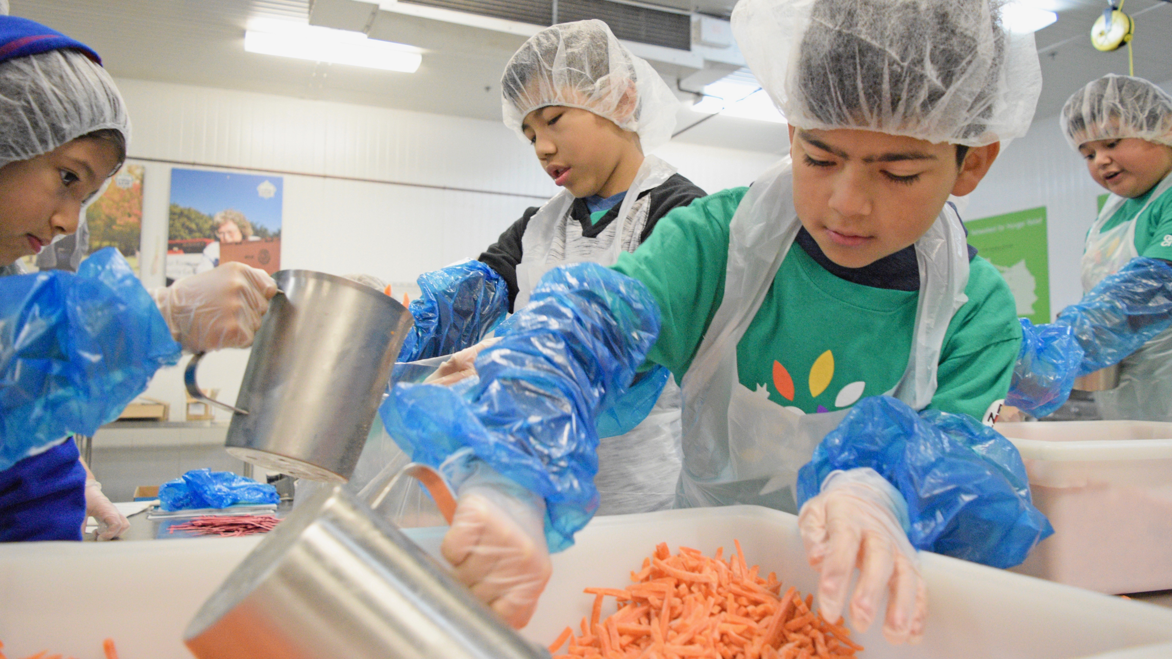 Young Comcast Cares Day volunteers prepare food.