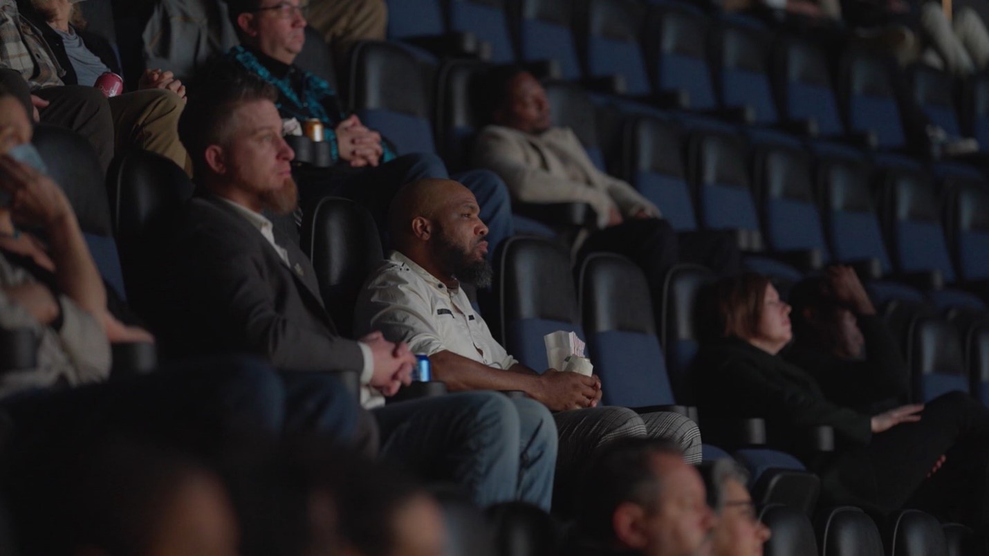 People watch a movie in a movie theater.