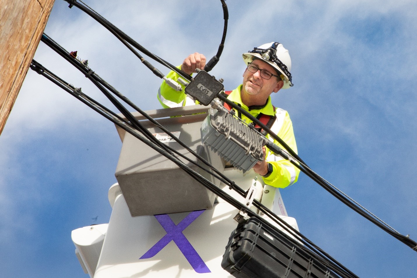 A Comcast technician works on cables.