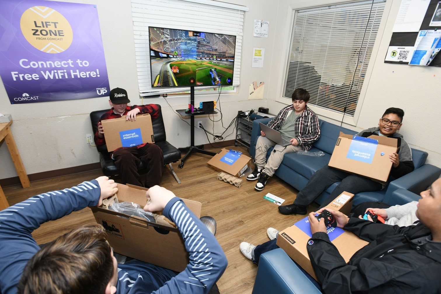 Youth receive laptops in a Comcast Lift Zone Lab.