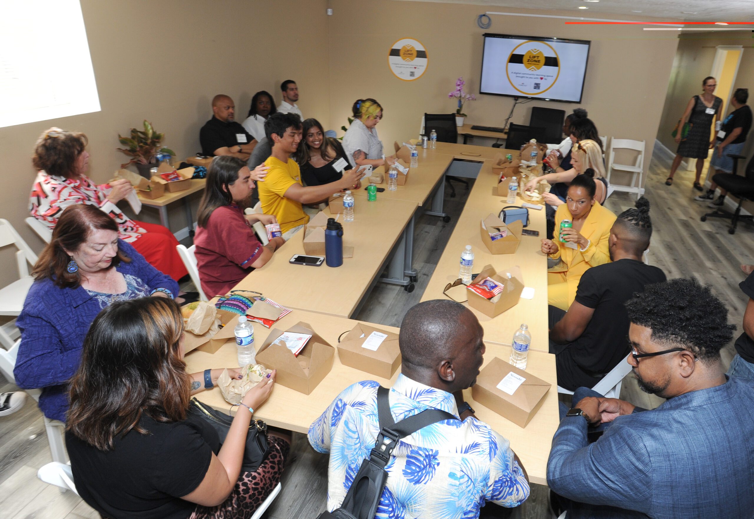 A digital equity roundtable with people sitting around a table. 