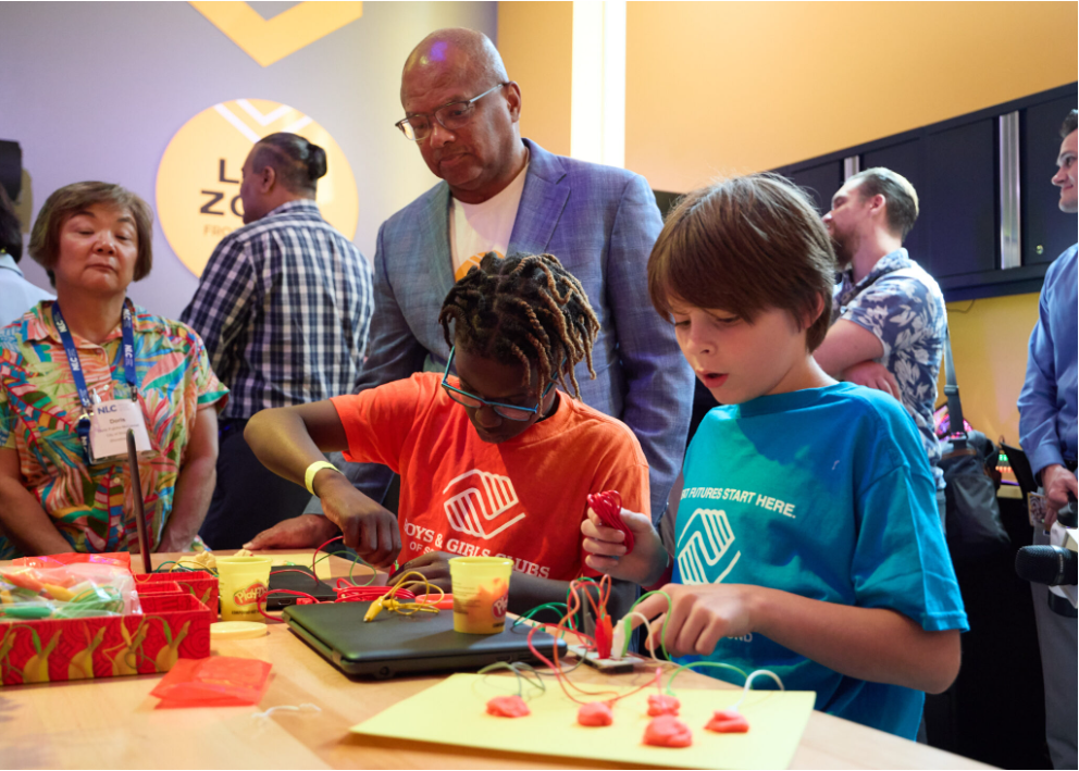 Comcast's Broderick Johnson works at a Lift Zone Lab with students.